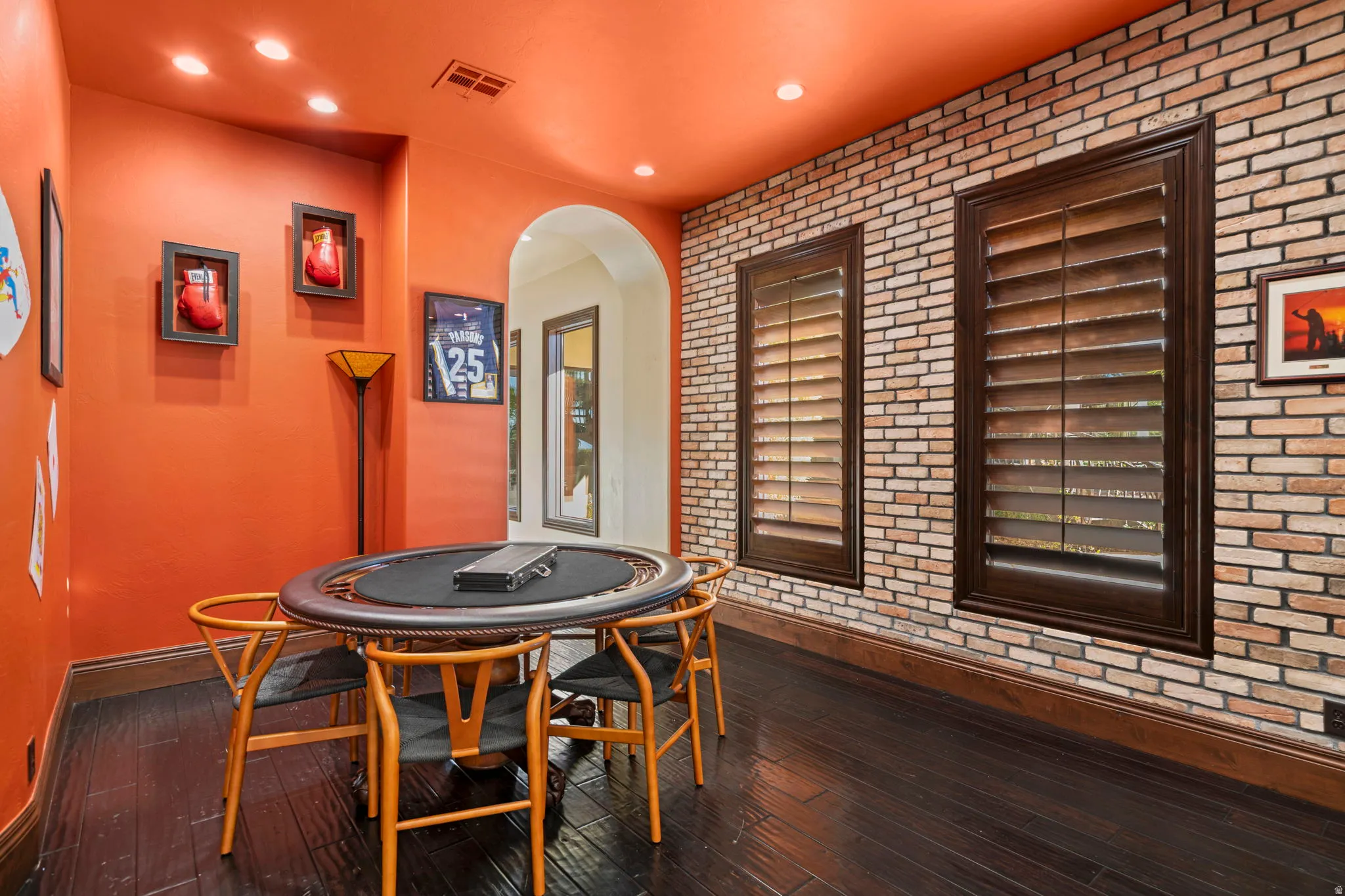 Game room featuring brick wall, dark wood-type flooring, and recessed lighting