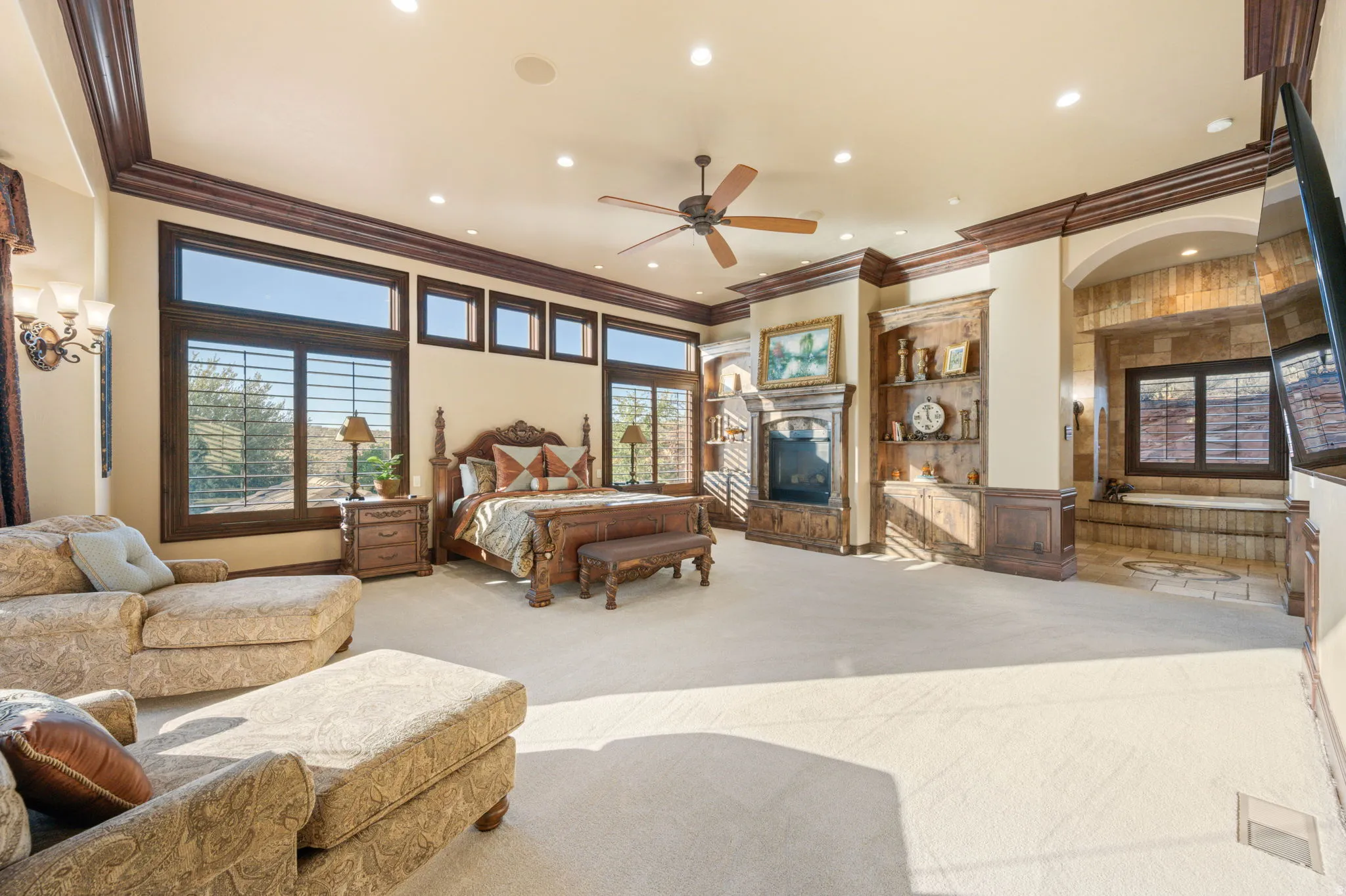 Bedroom with a glass covered fireplace, ornamental molding, carpet, and recessed lighting
