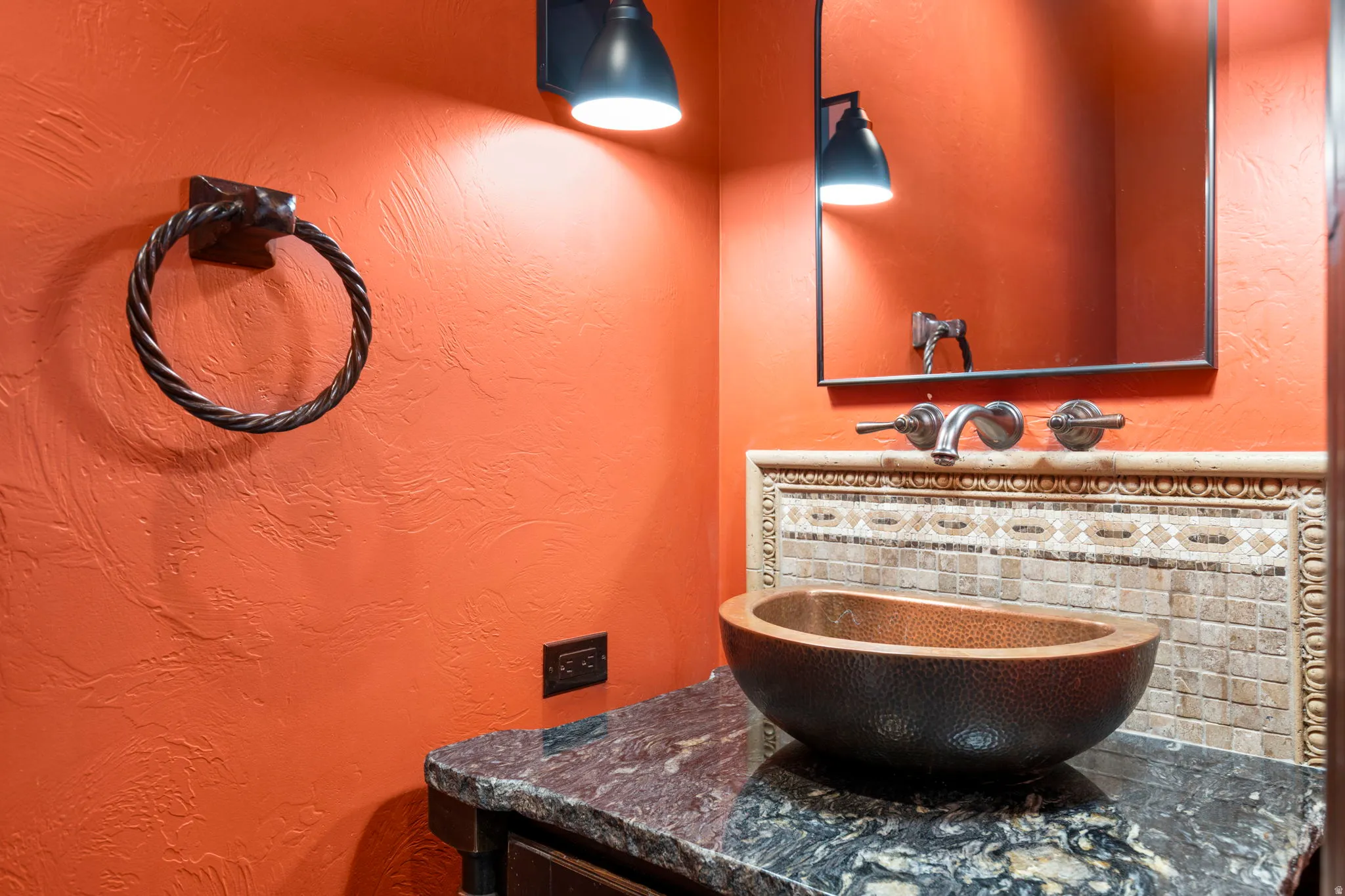 Bathroom with a textured wall and vanity