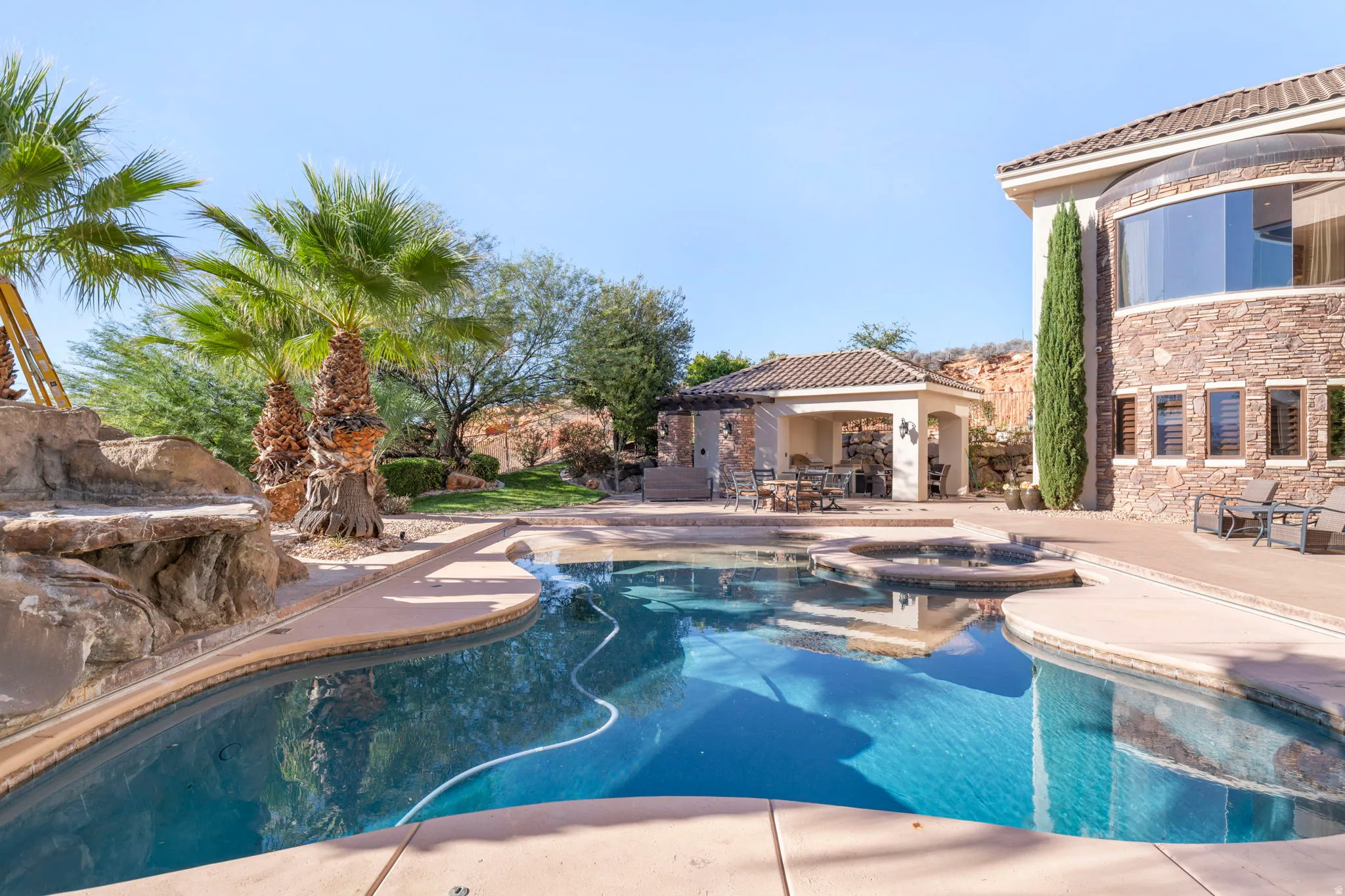 View of pool featuring a patio, a pool with connected hot tub, and a gazebo