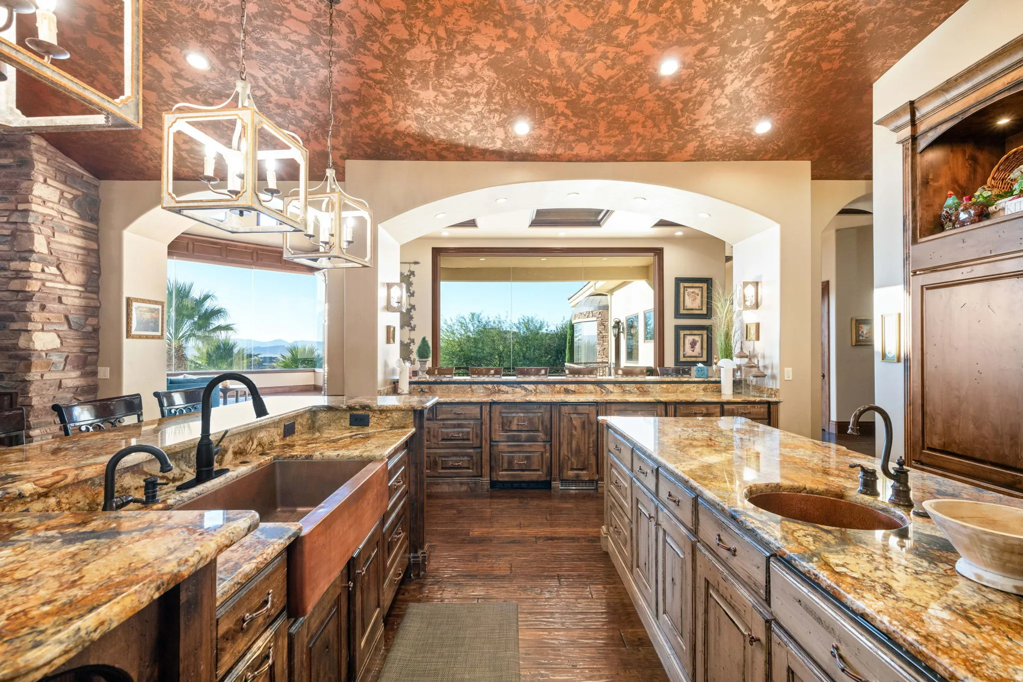 Kitchen with light stone counters, dark wood finished floors, hanging light fixtures, recessed lighting, and a breakfast bar