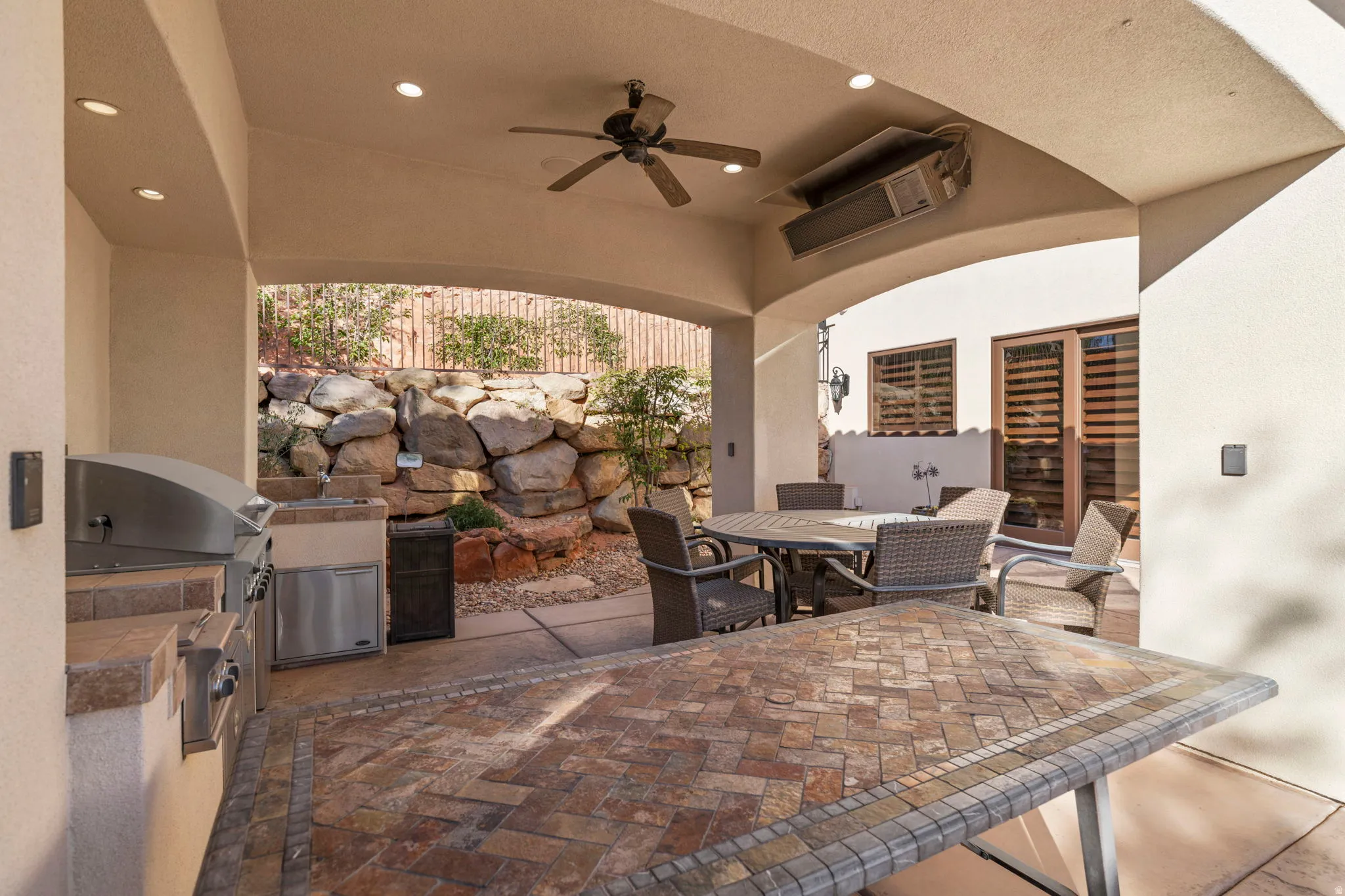 View of patio with outdoor dining area, ceiling fan, and an outdoor kitchen