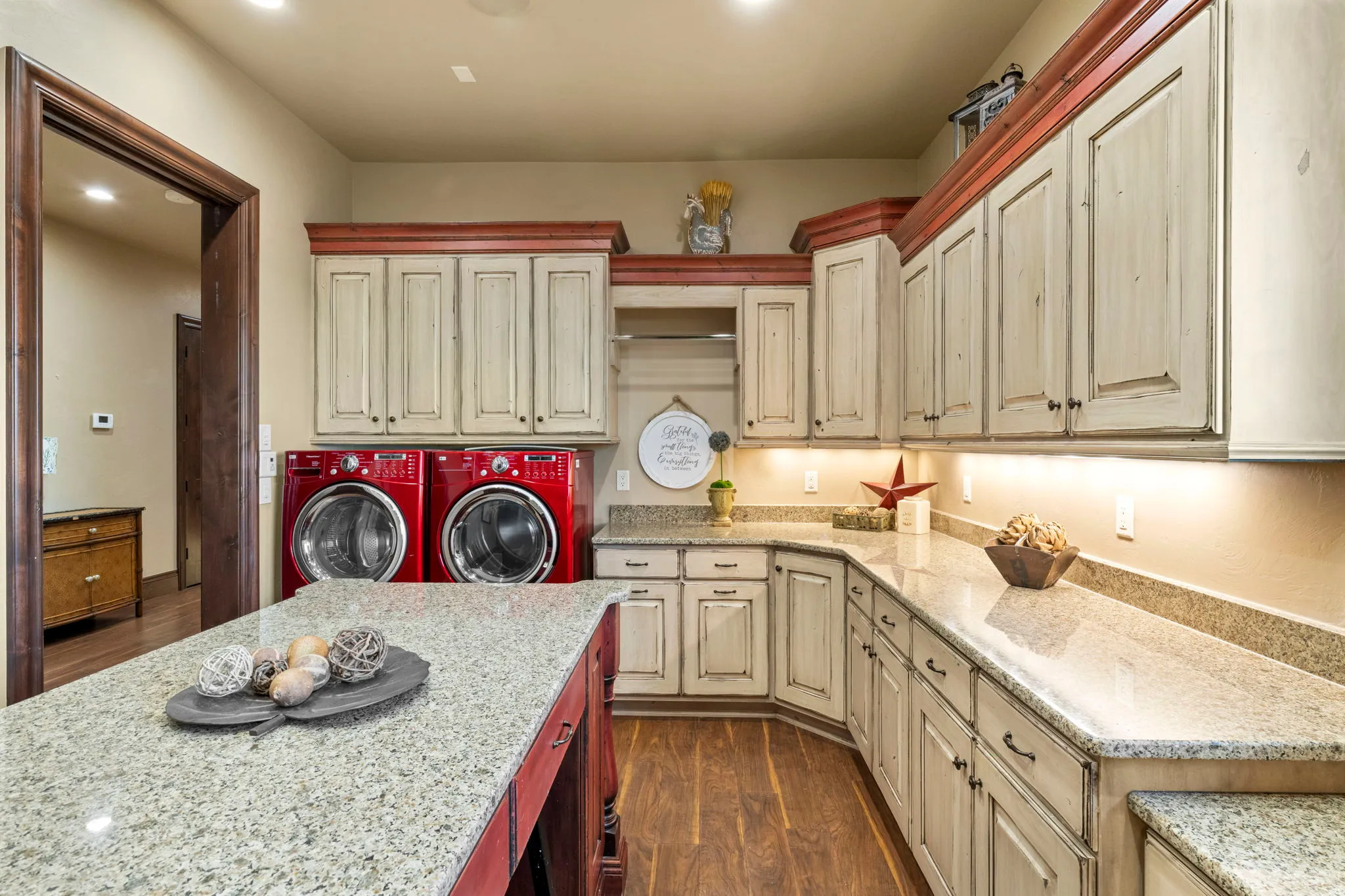 Laundry area featuring dark wood-style flooring, separate washer and dryer, cabinet space, and recessed lighting
