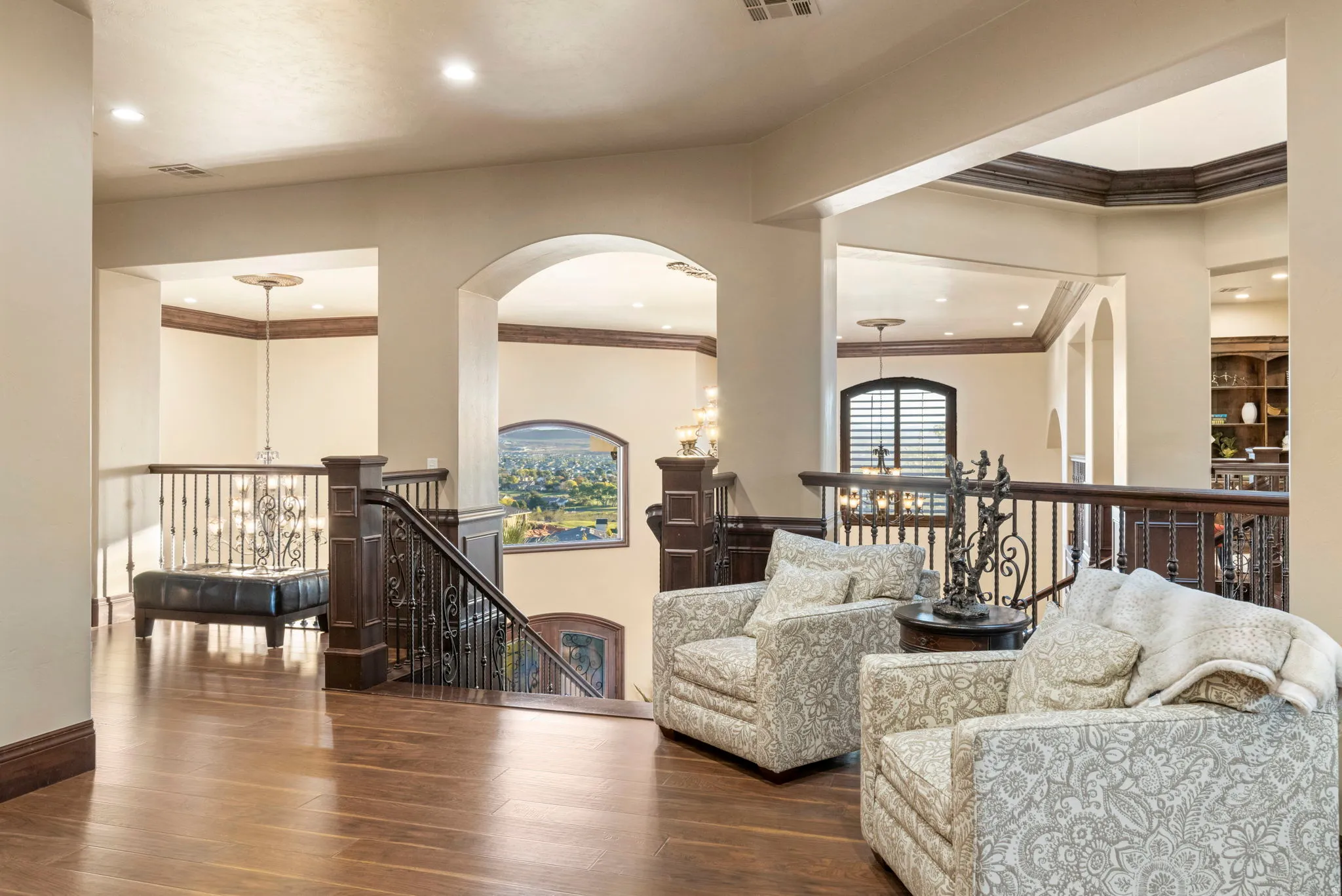 Living area with a chandelier, wood finished floors, ornamental molding, recessed lighting, and arched walkways