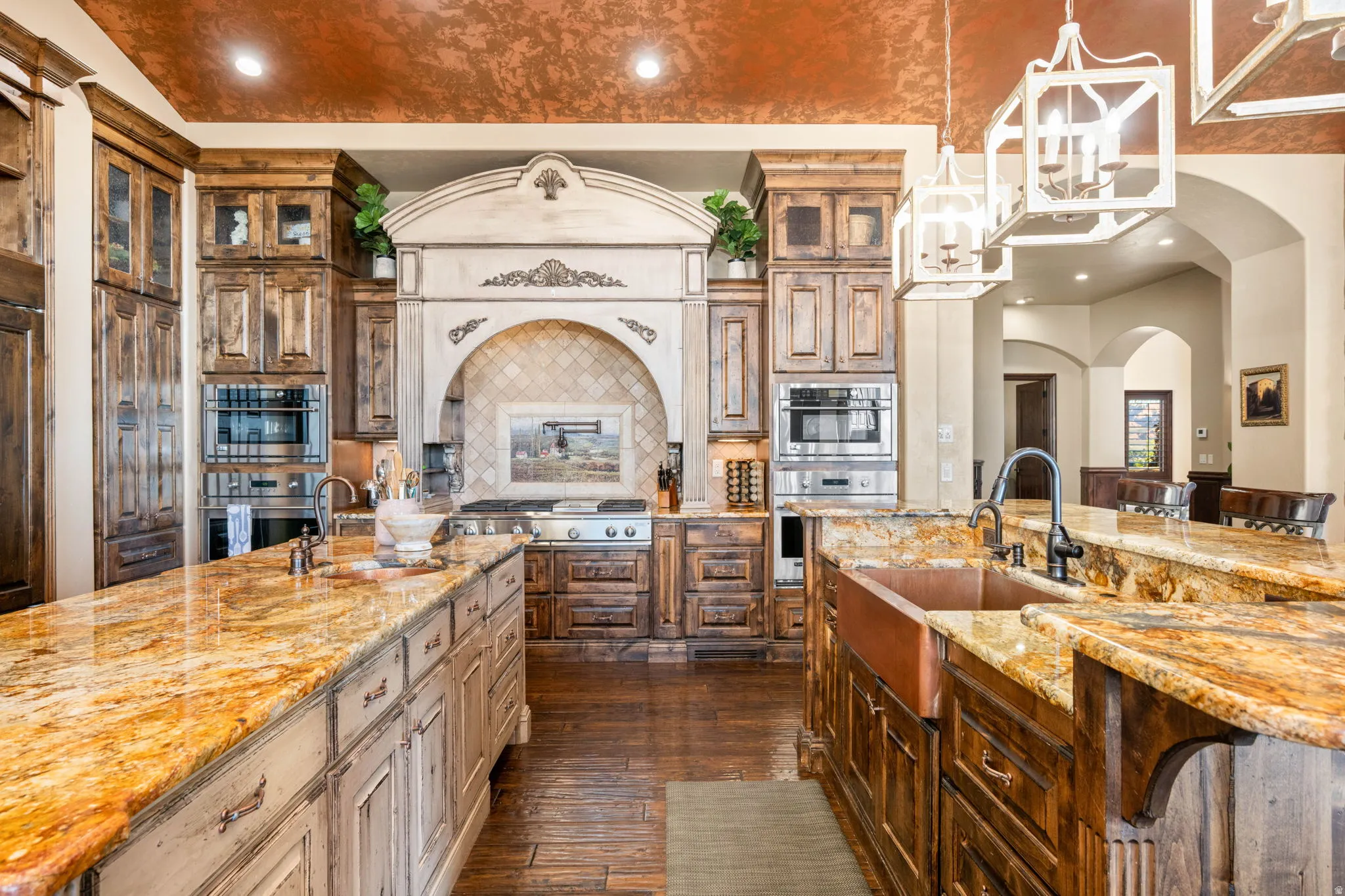 Kitchen featuring pendant lighting, light stone countertops, dark wood-style floors, decorative backsplash, and glass insert cabinets