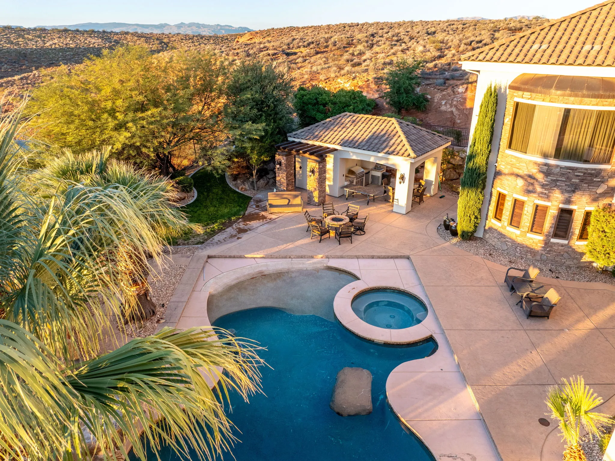 View of pool featuring a patio area, a pool with connected hot tub, a fire pit, and a mountain view