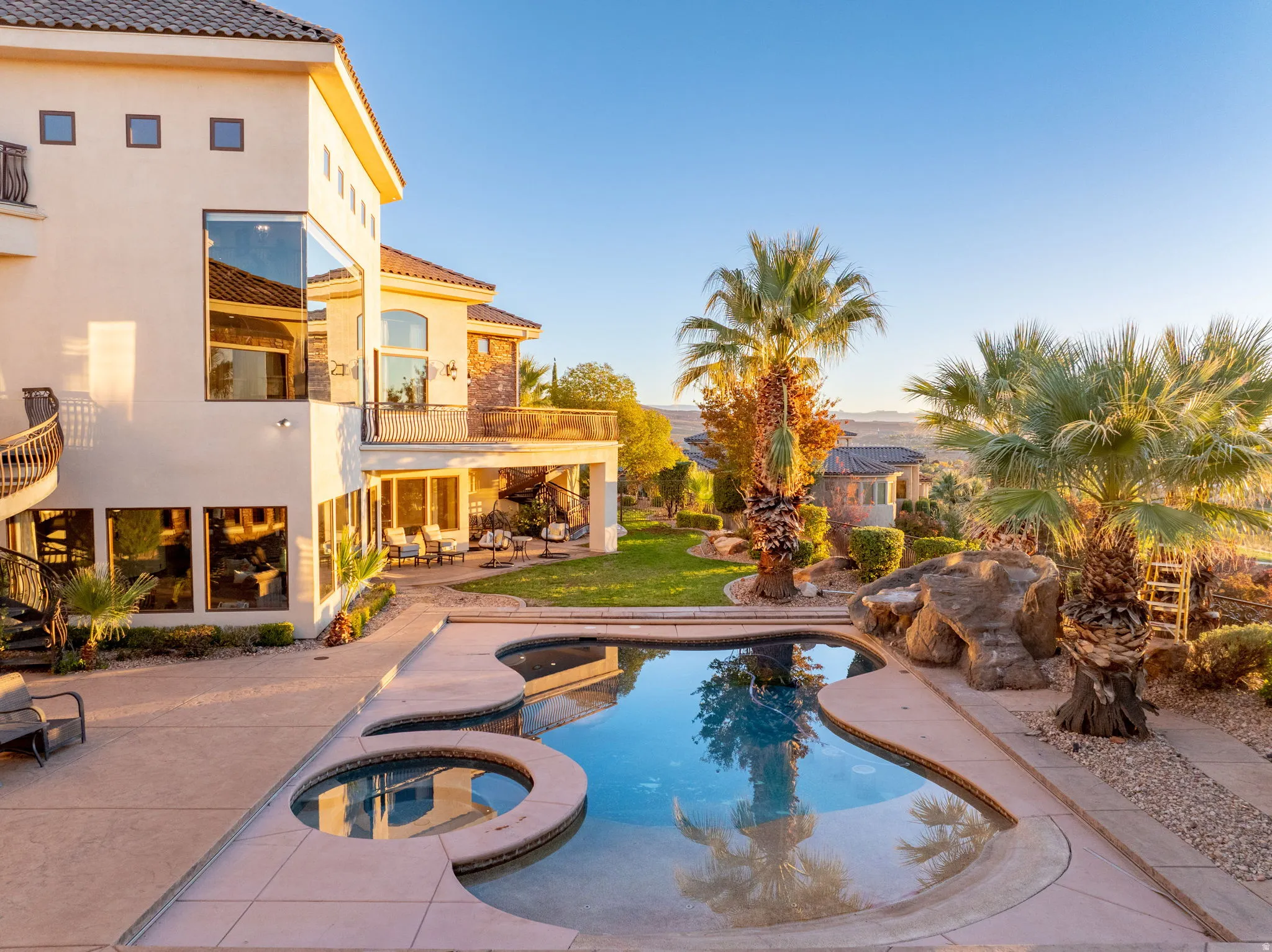 View of swimming pool with stairway, a patio area, a pool with connected hot tub, a balcony, and outdoor lounge area