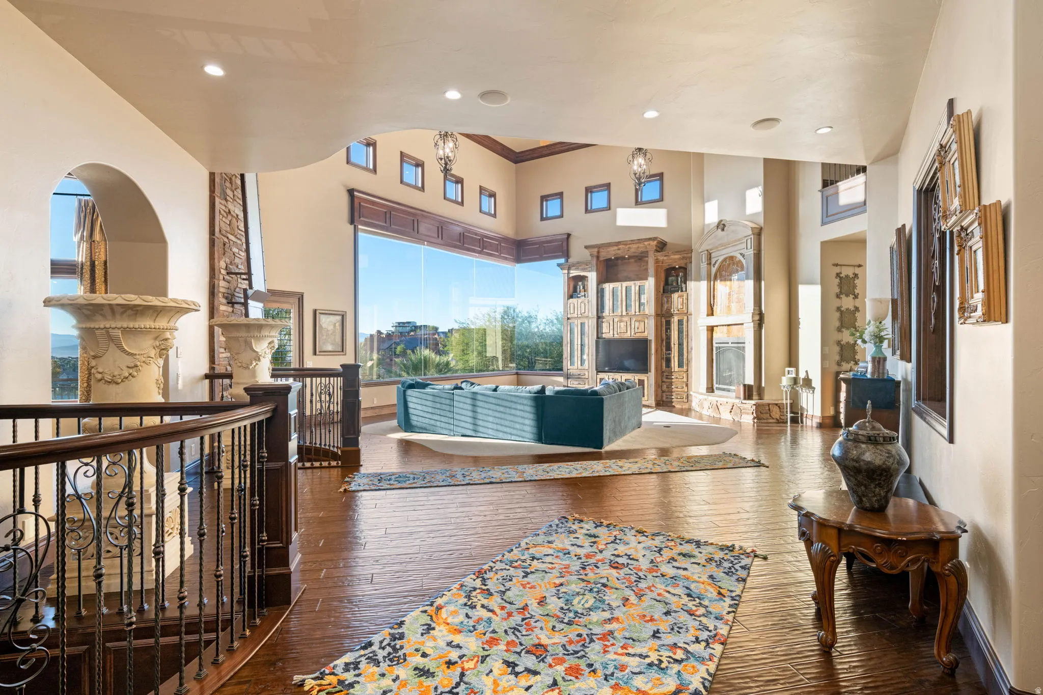 Living room with a glass covered fireplace, dark wood finished floors, crown molding, a towering ceiling, and recessed lighting
