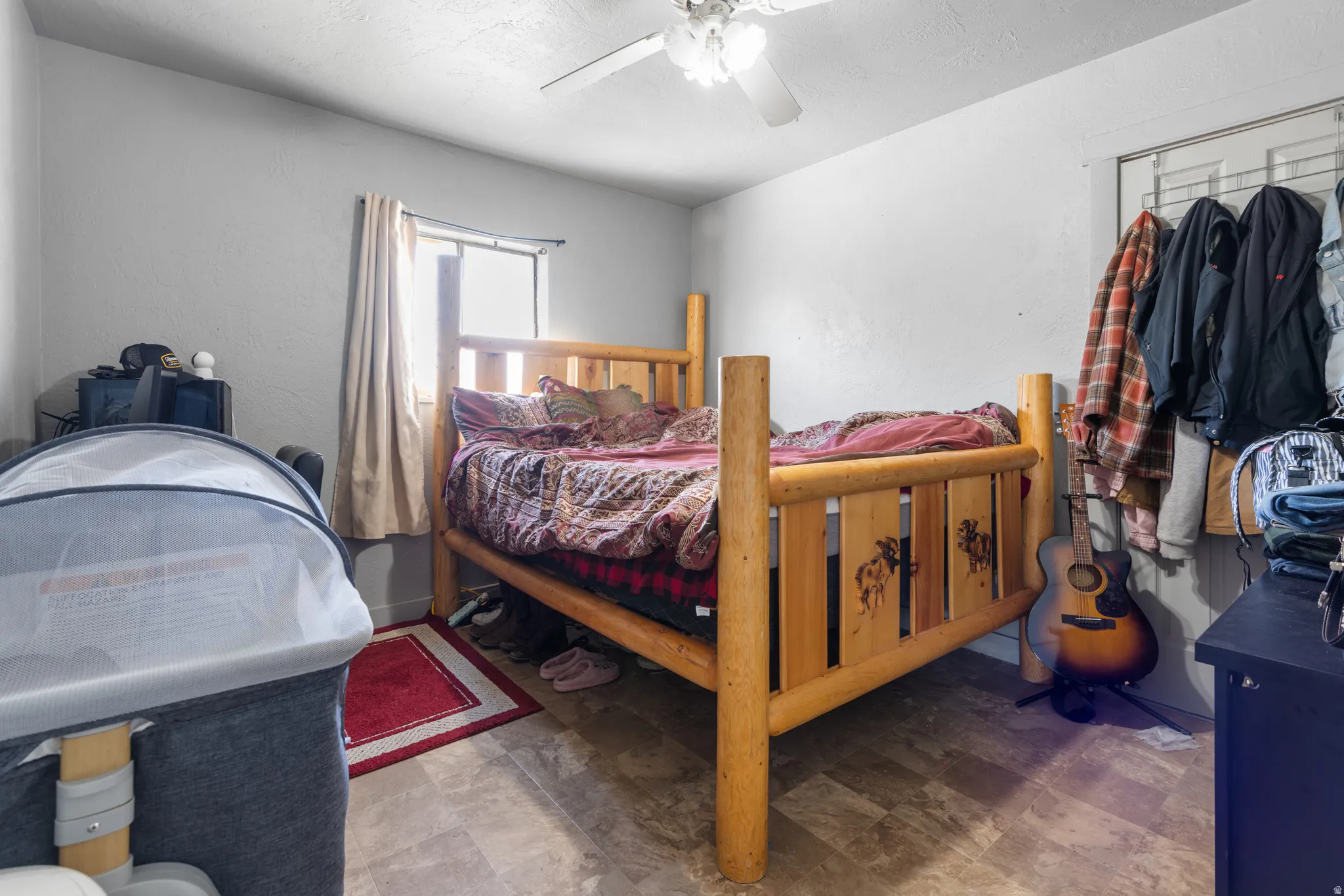 Bedroom featuring a ceiling fan and a textured wall