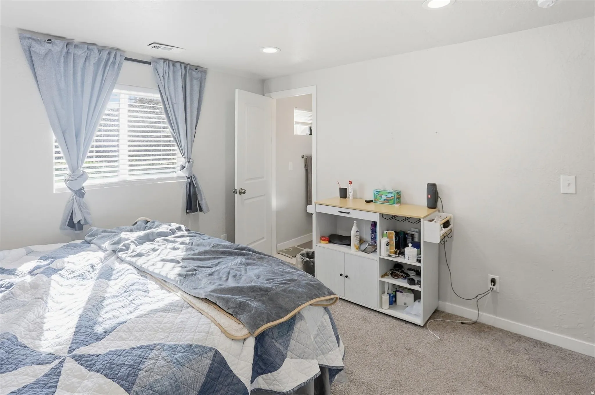 Bedroom with light colored carpet and recessed lighting