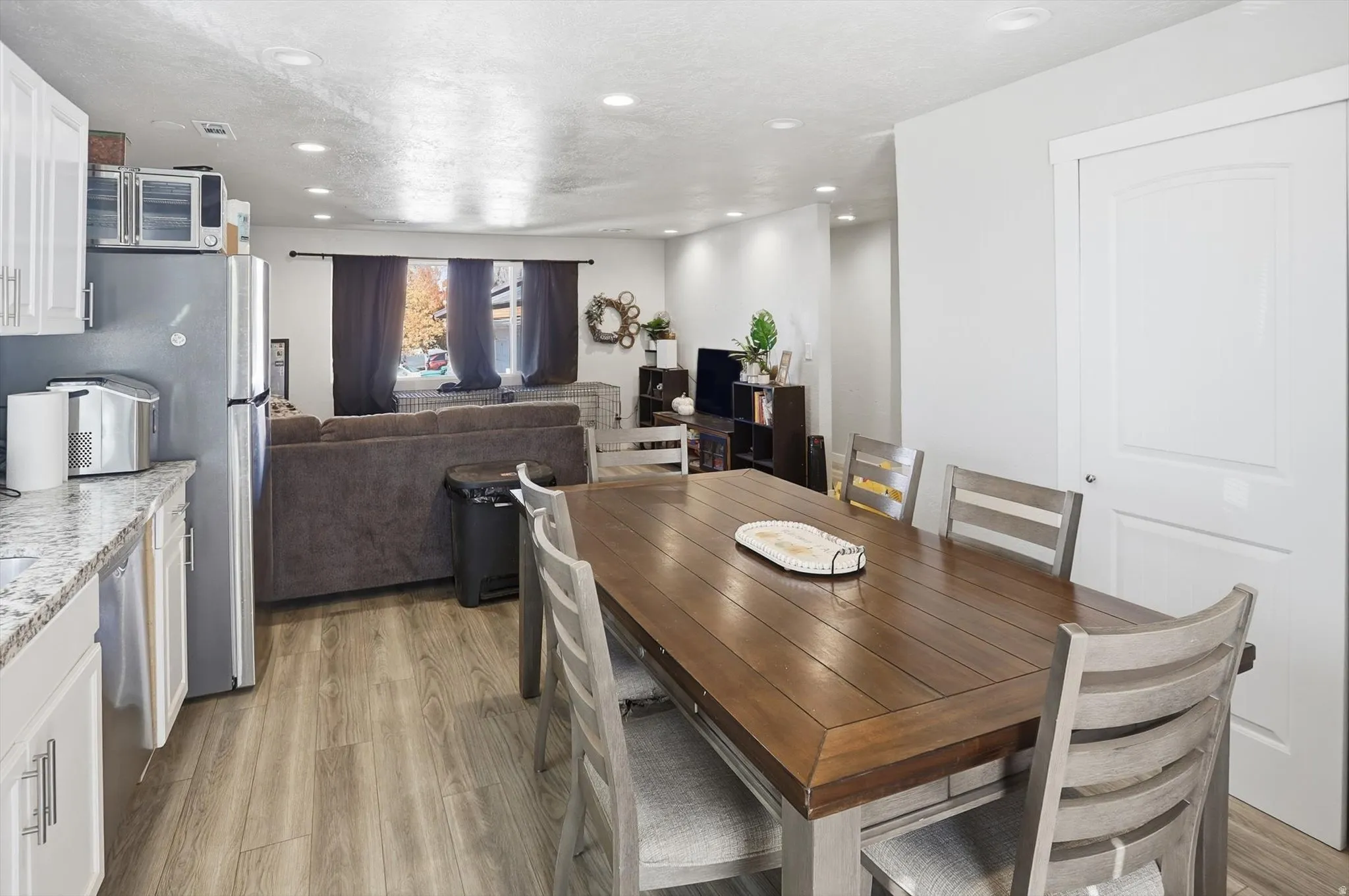 Dining room featuring light wood finished floors, recessed lighting, and a textured ceiling