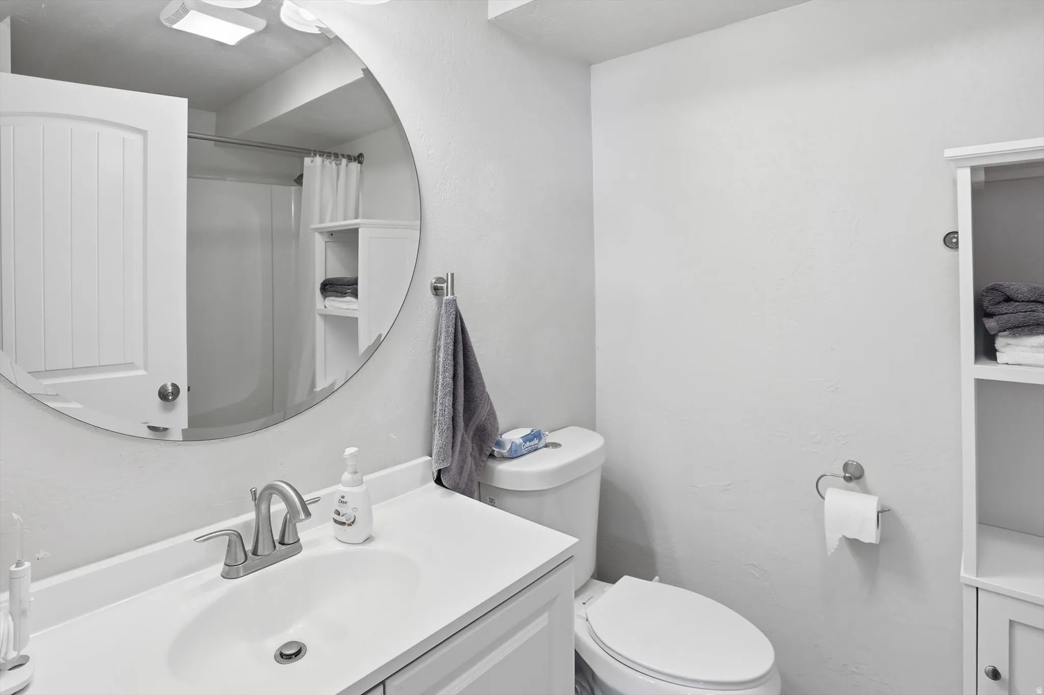 Bathroom with vanity, curtained shower, and a textured wall