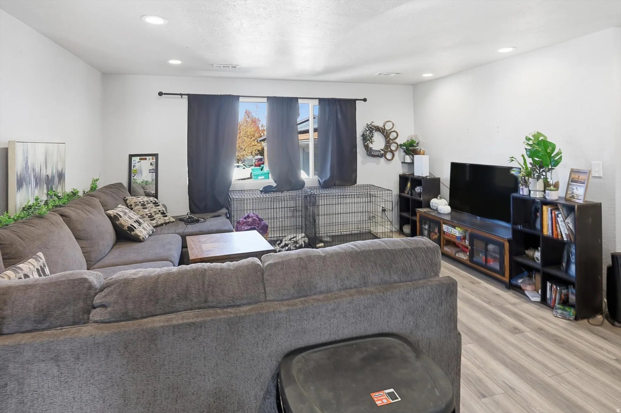 Living area with recessed lighting, wood finished floors, and a textured ceiling
