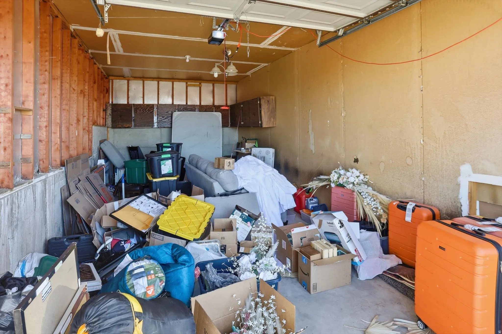 Garage featuring a garage door opener. Other side has added space for workshop