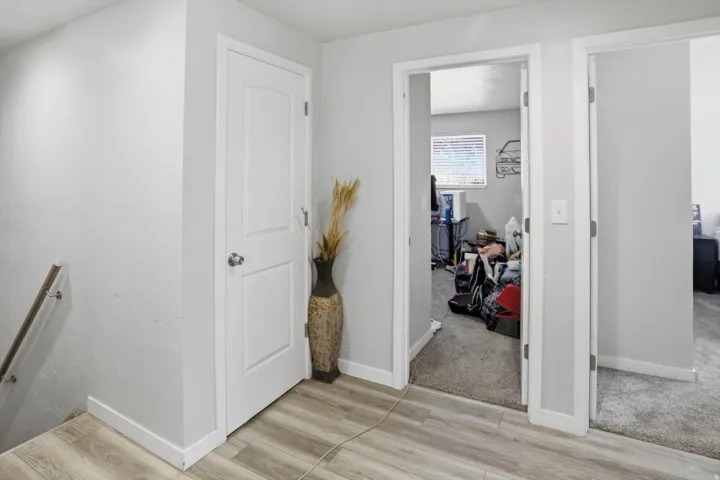Hall with light wood-style flooring, light colored carpet, and an upstairs landing