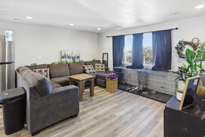 Living area with light wood-style floors and recessed lighting