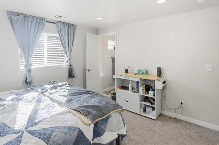 Bedroom with light colored carpet and recessed lighting