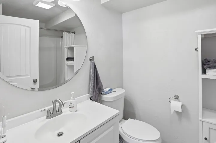 Bathroom with vanity, curtained shower, and a textured wall