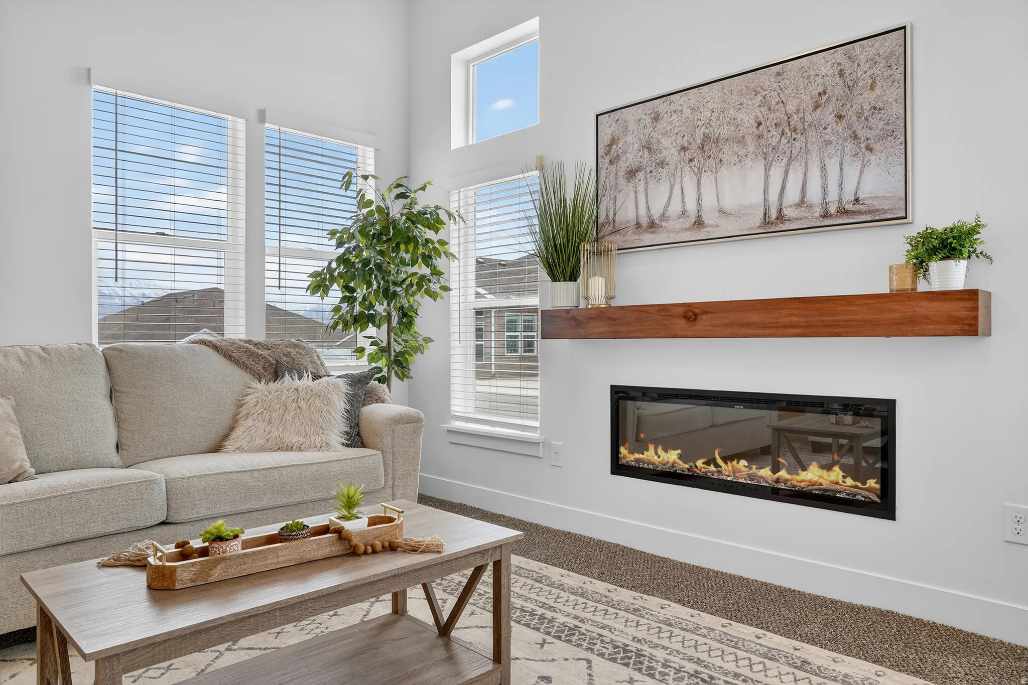 Living room featuring a glass covered fireplace, vaulted ceiling, recessed lighting.