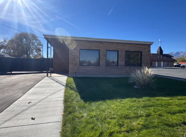 View of side of property featuring brick siding and a gate