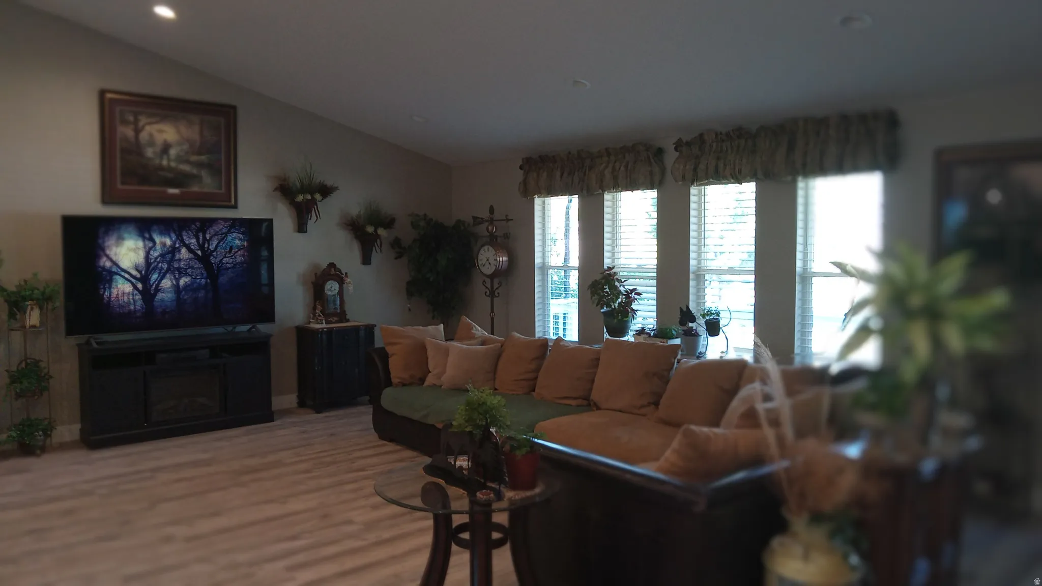 Living area with vaulted ceiling, wood finished floors, and recessed lighting