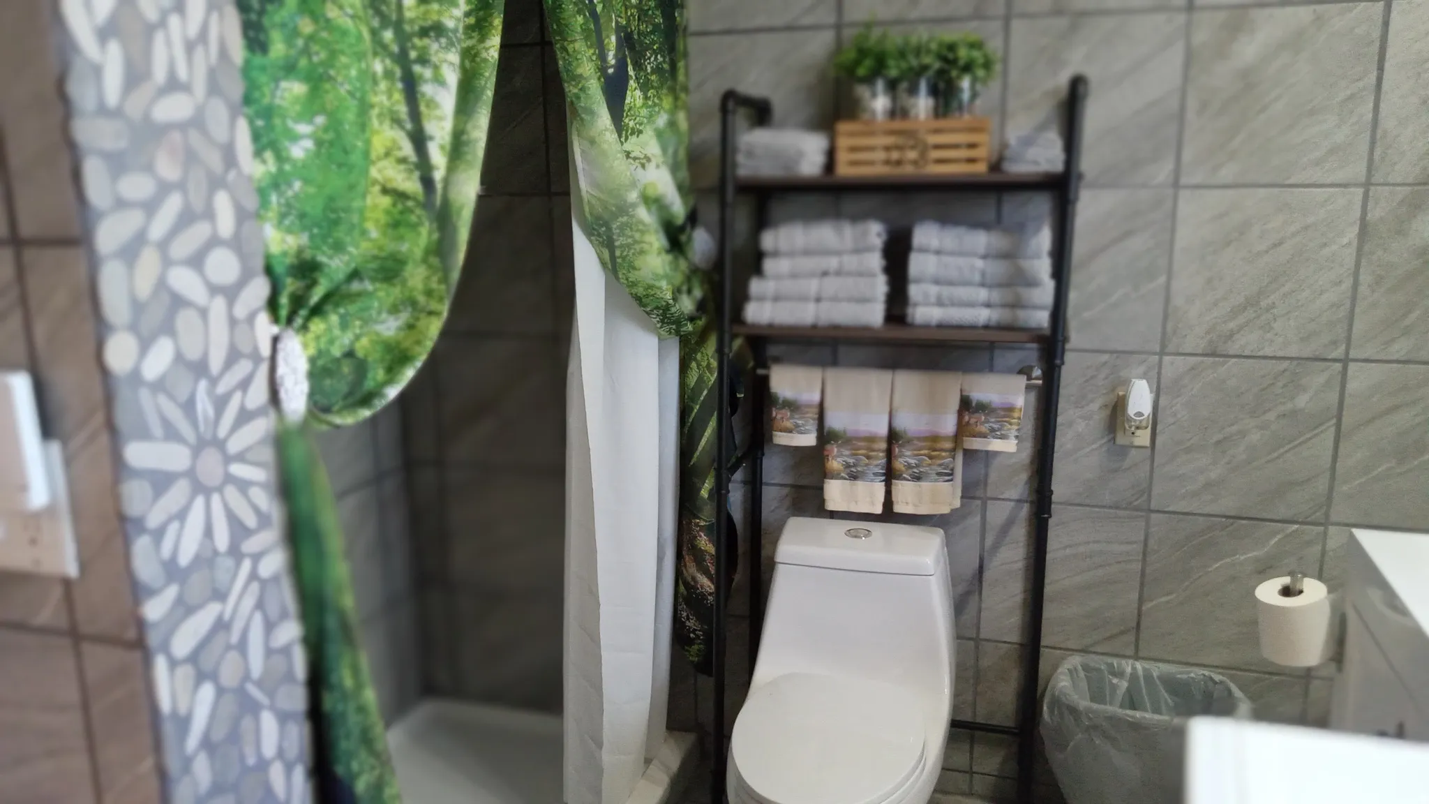Full bathroom with a shower stall, vanity, and tile walls