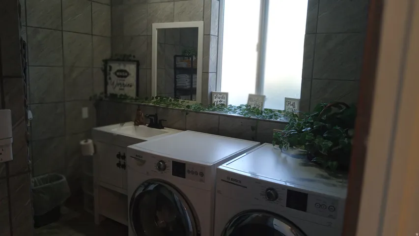 Laundry room featuring washer / dryer and tile walls