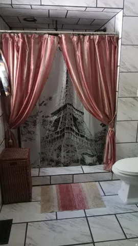 Full bath featuring a shower stall, tile walls, and light marble finish floors