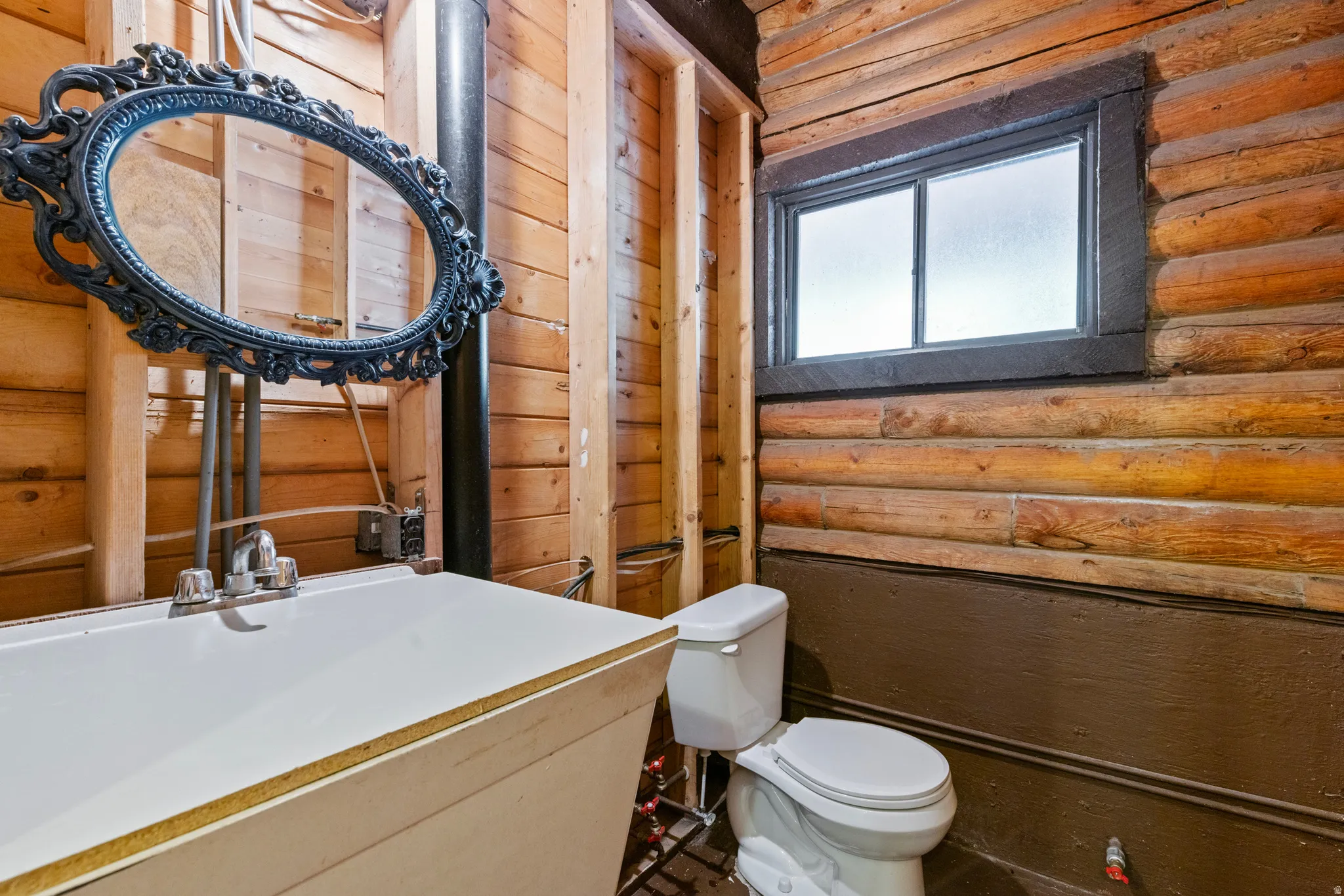 Bathroom featuring rustic walls and vanity