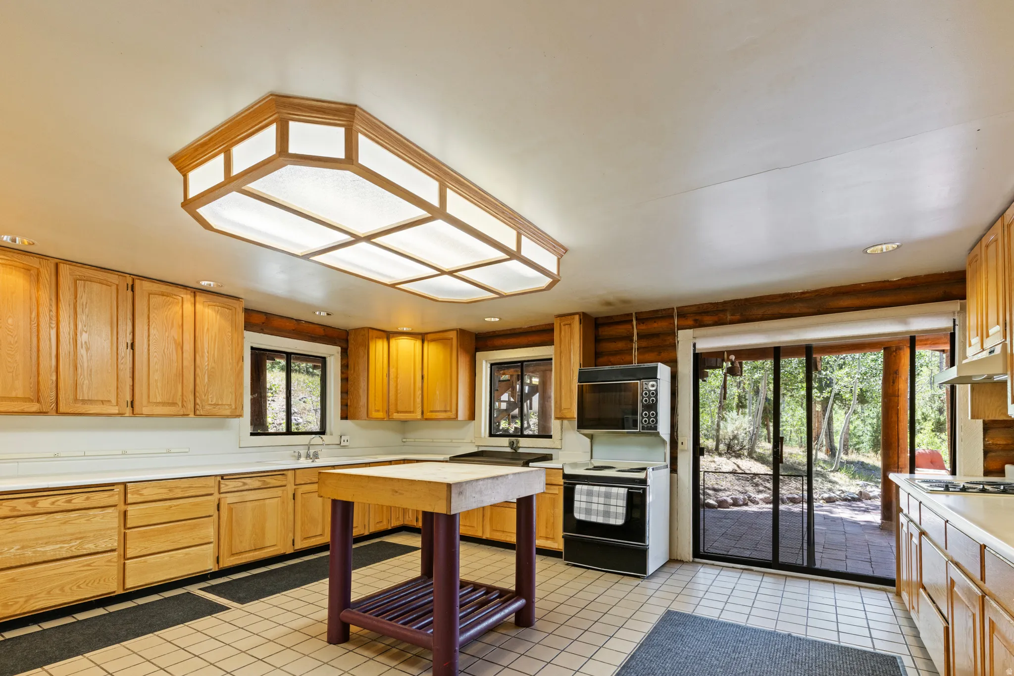Kitchen featuring light countertops, electric range oven, and light tile patterned floors