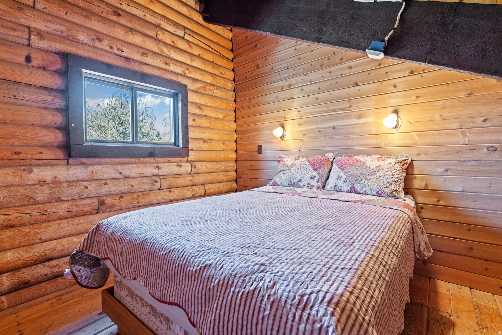 Bedroom featuring log walls and wood-type flooring