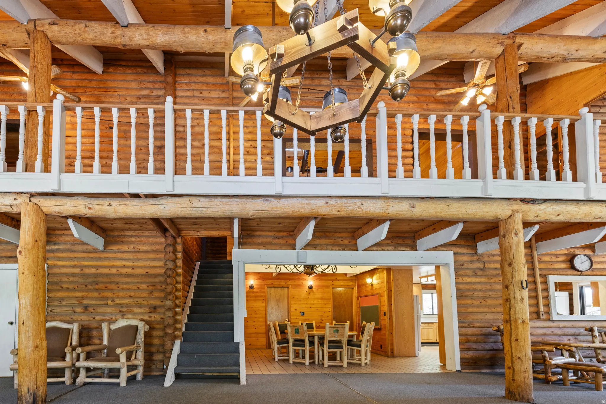Exterior space featuring log siding, a wooden deck, stairway, and outdoor dining area