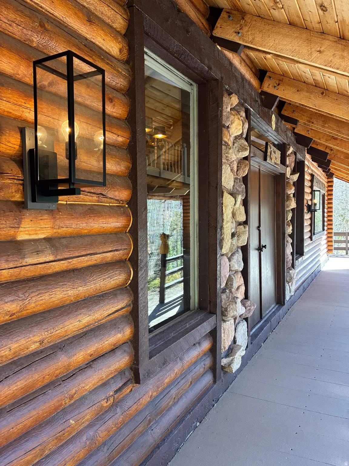 Entrance to property with stone siding and log exterior