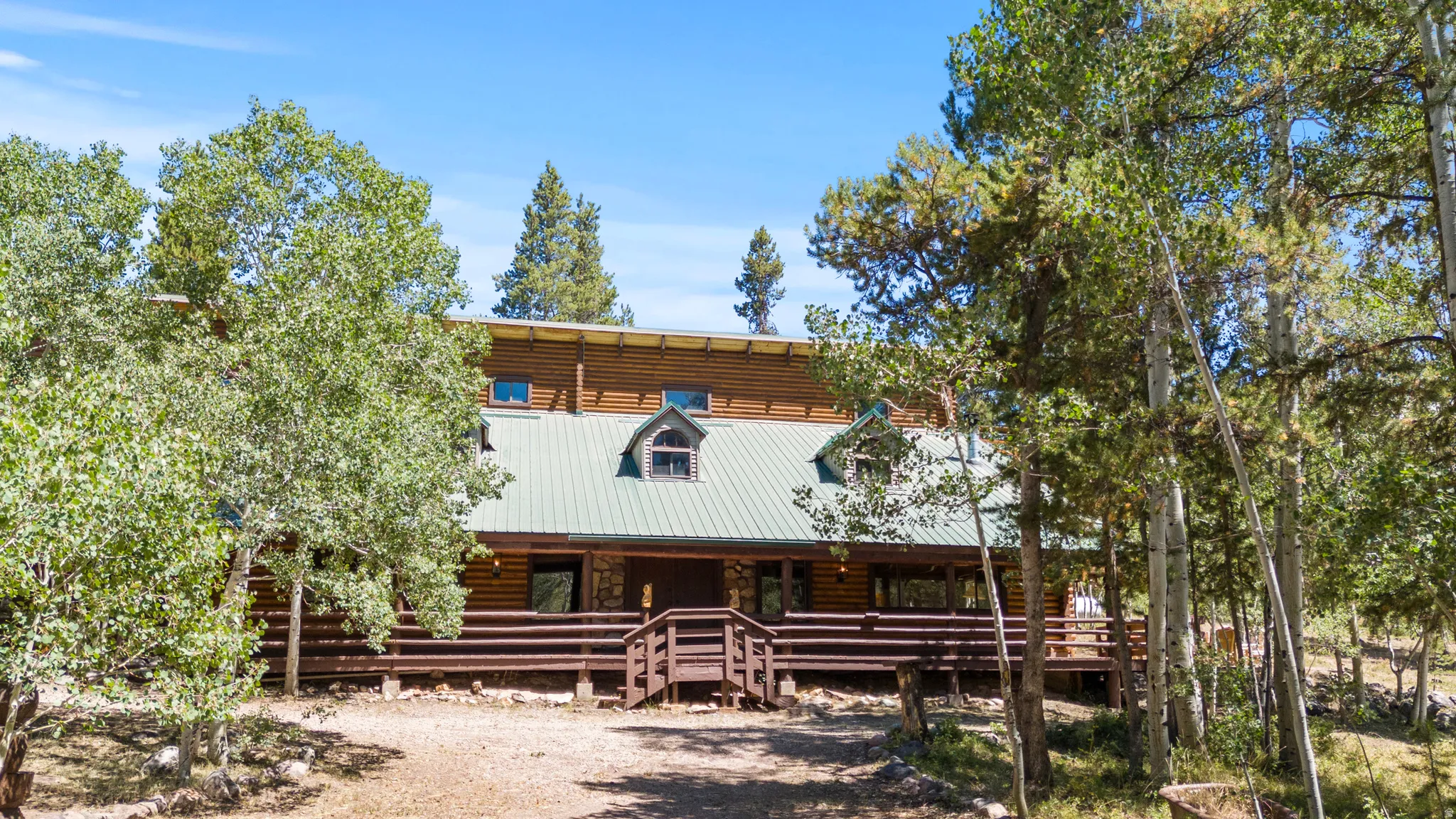 Log home featuring covered porch and a metal roof