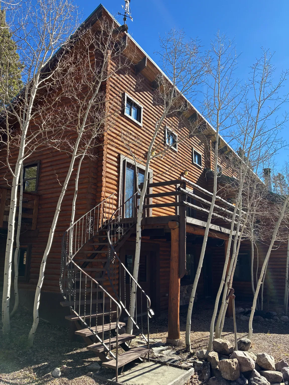 Rear view of house featuring stairs, a wooden deck, and log exterior