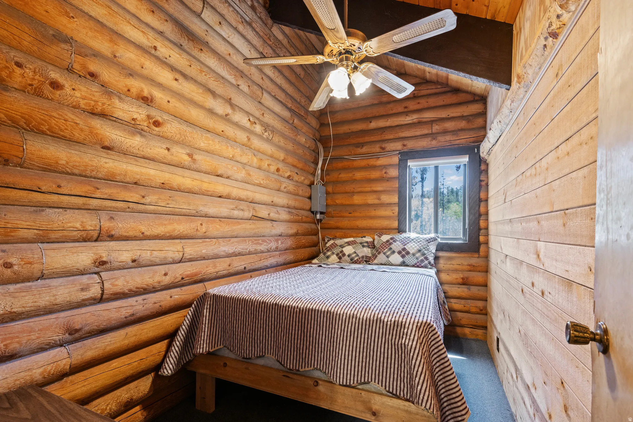 Carpeted bedroom featuring rustic walls, a sauna / steam room, a ceiling fan, wooden ceiling, and vaulted ceiling