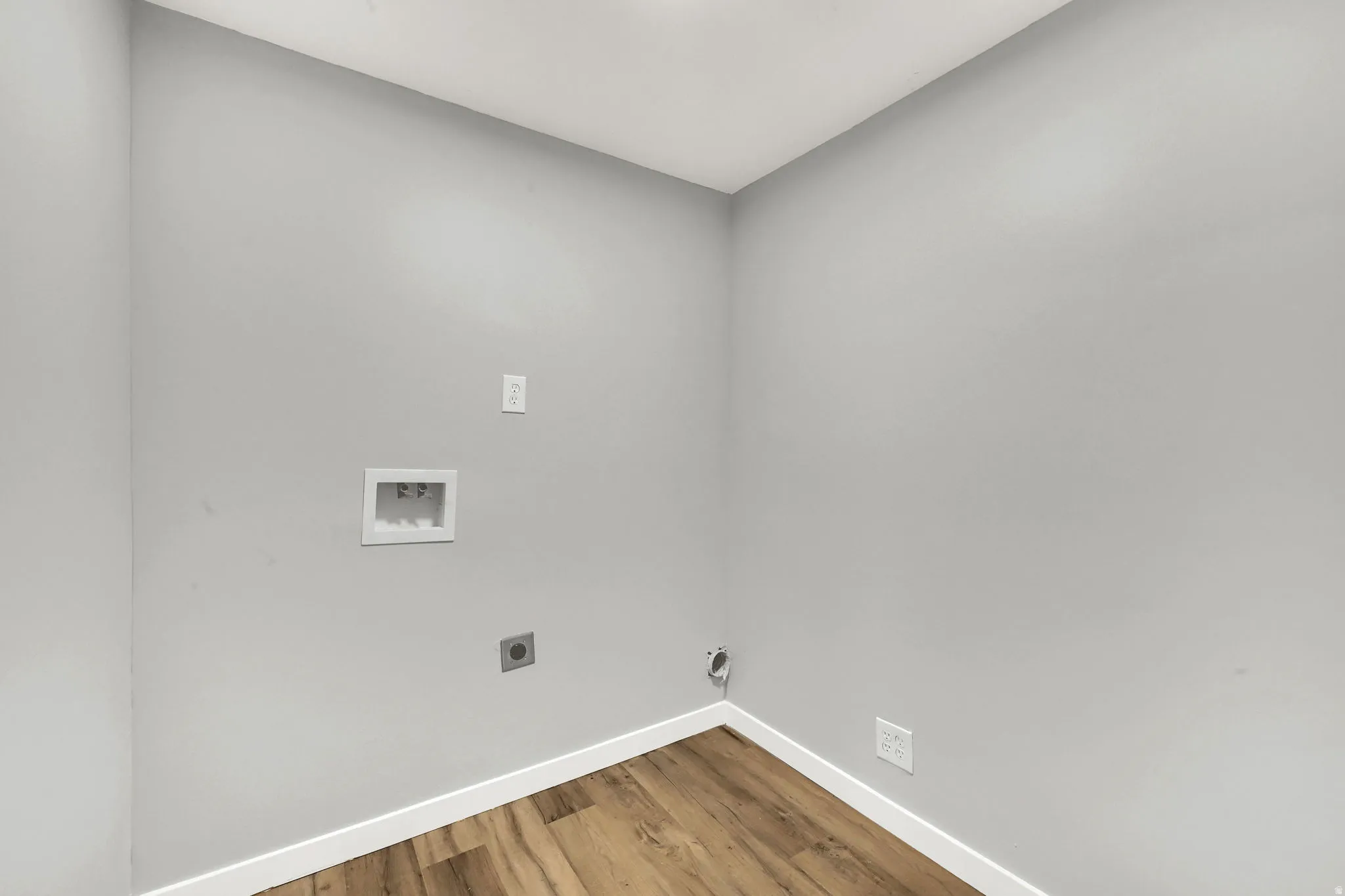 Laundry area with wood finished floors, washer hookup, and electric dryer hookup