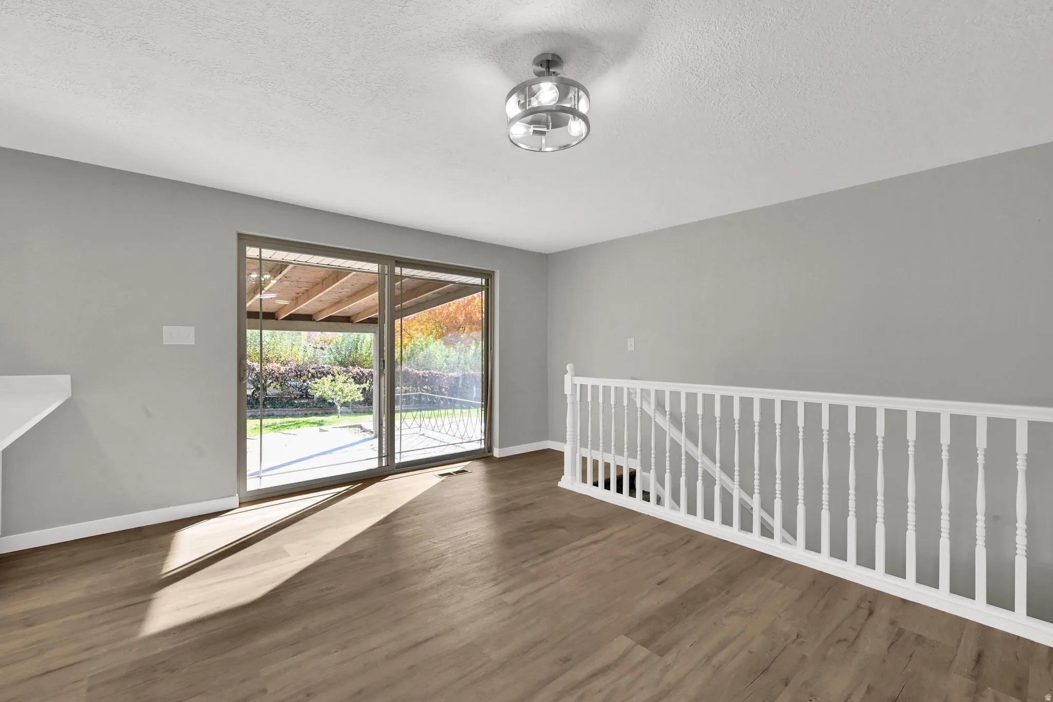 Unfurnished room with wood finished floors and a textured ceiling