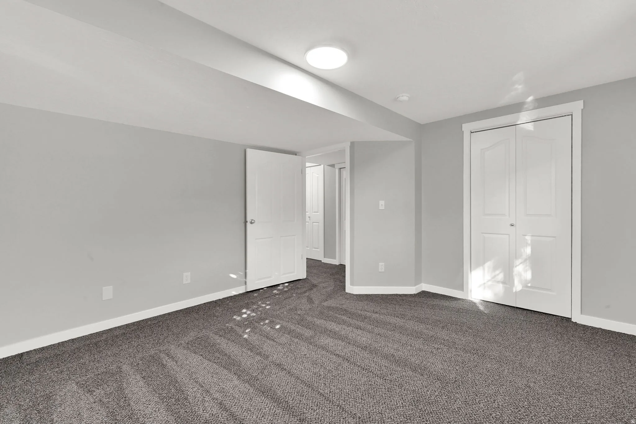 Unfurnished bedroom featuring dark carpet and a closet