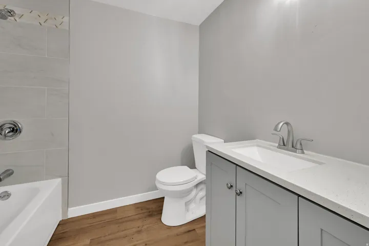 Bathroom featuring vanity, light wood-style floors, and  shower combination