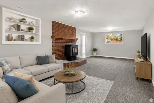 Built-in shelving, brick accent wall with a wood-burning stove, recessed lighting, and a large window with natural light