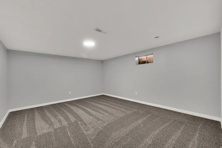 Carpeted spare room featuring baseboards