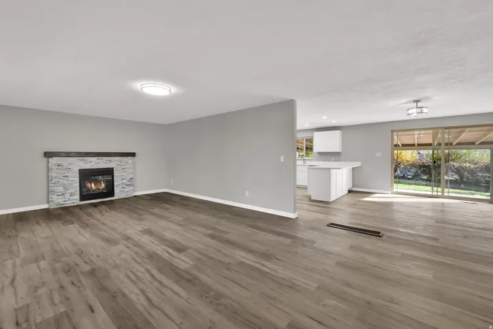 Unfurnished living room with dark wood-style floors, a fireplace, and recessed lighting