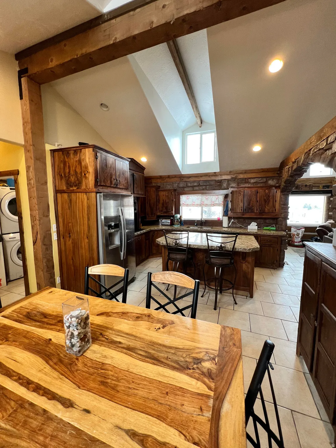 Dining area with light tile patterned floors, estacked washer and dryer, and recessed lighting