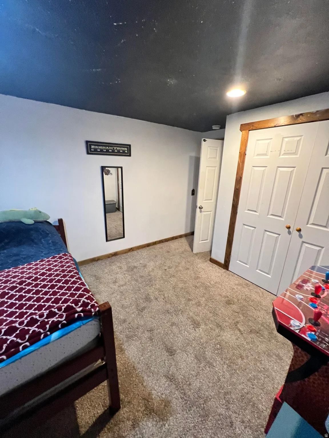 Carpeted bedroom featuring a closet and baseboards
