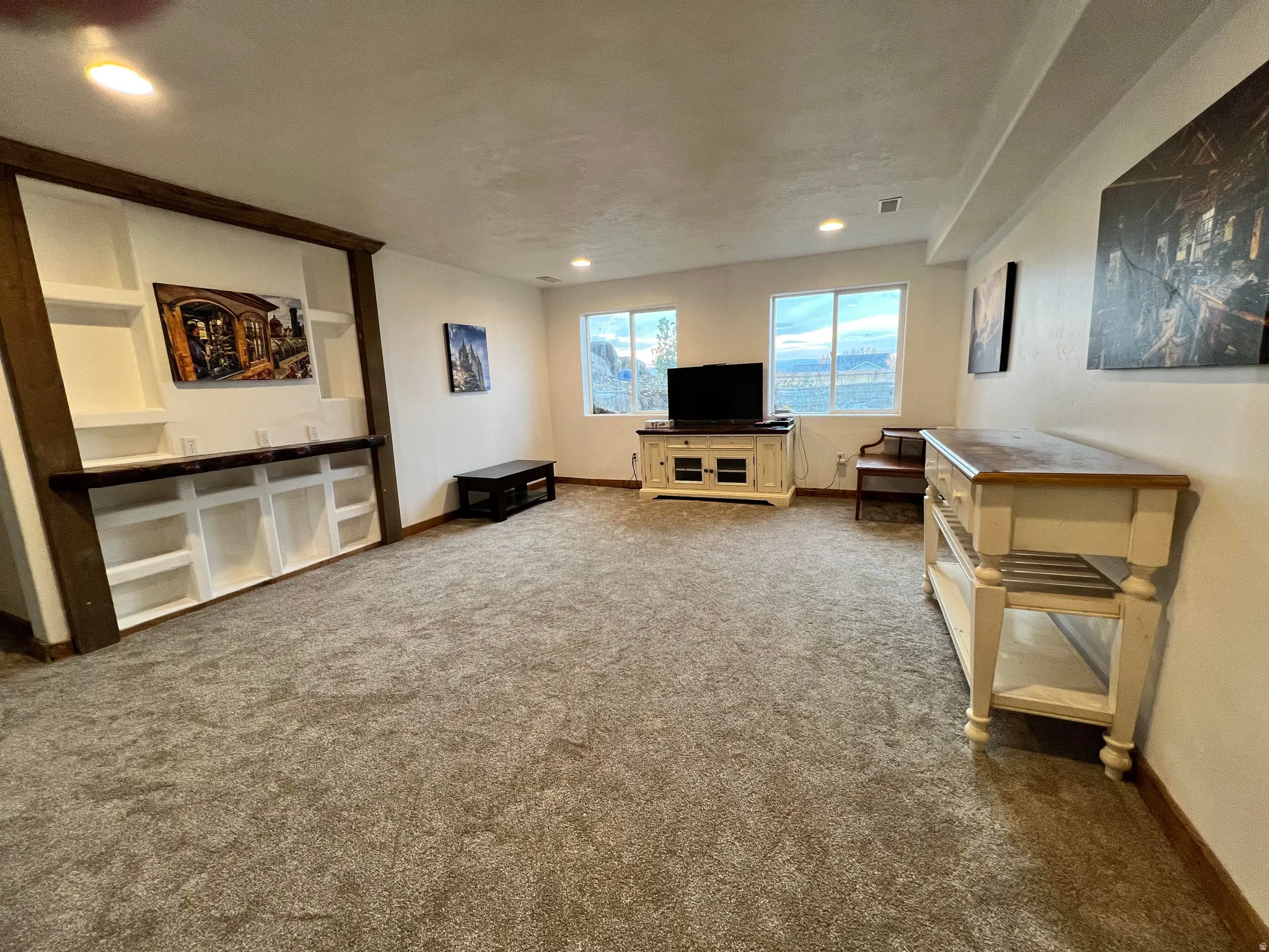 Living room with dark carpet and recessed lighting