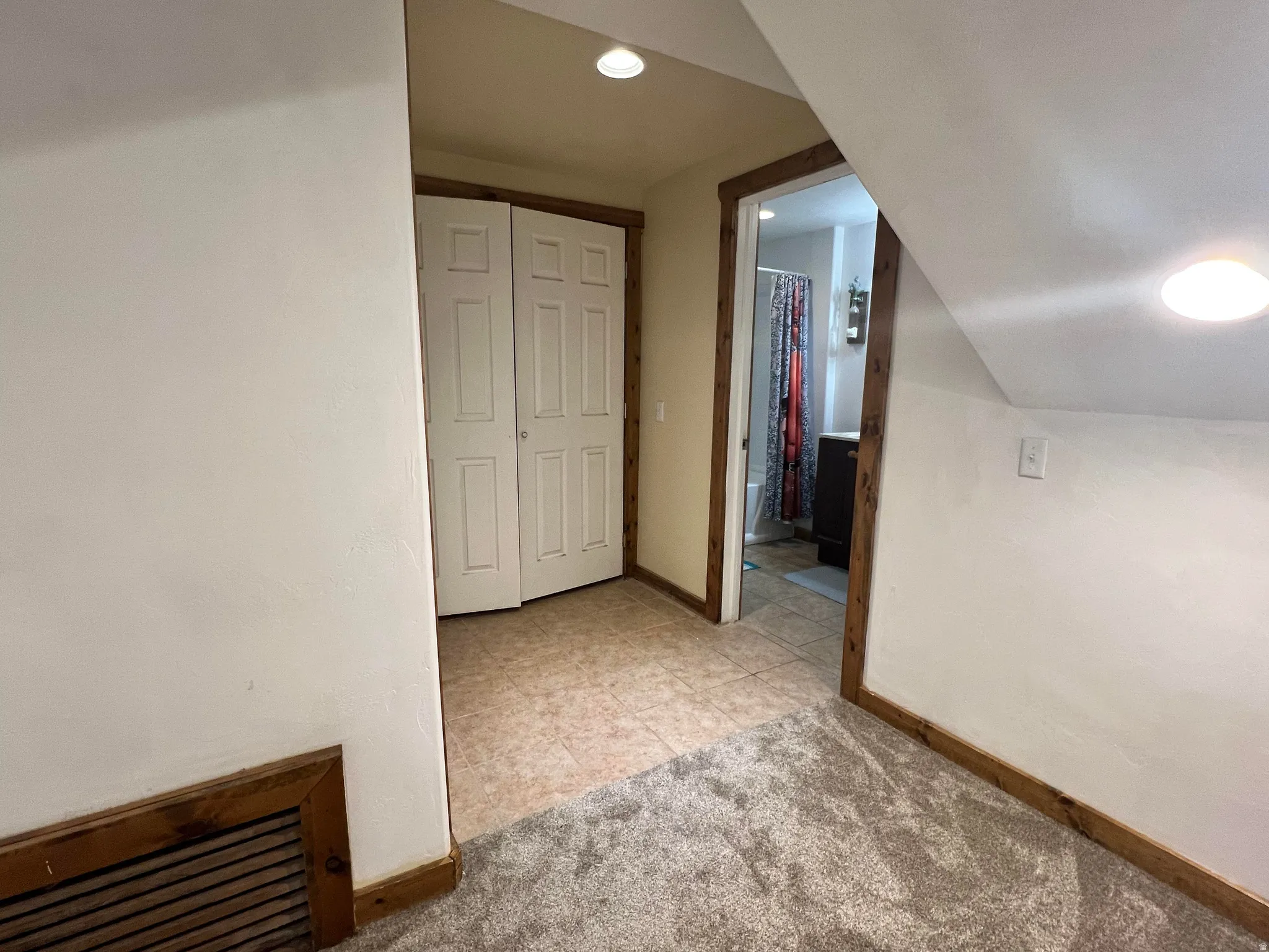 Bonus room with light tile patterned flooring and light carpet