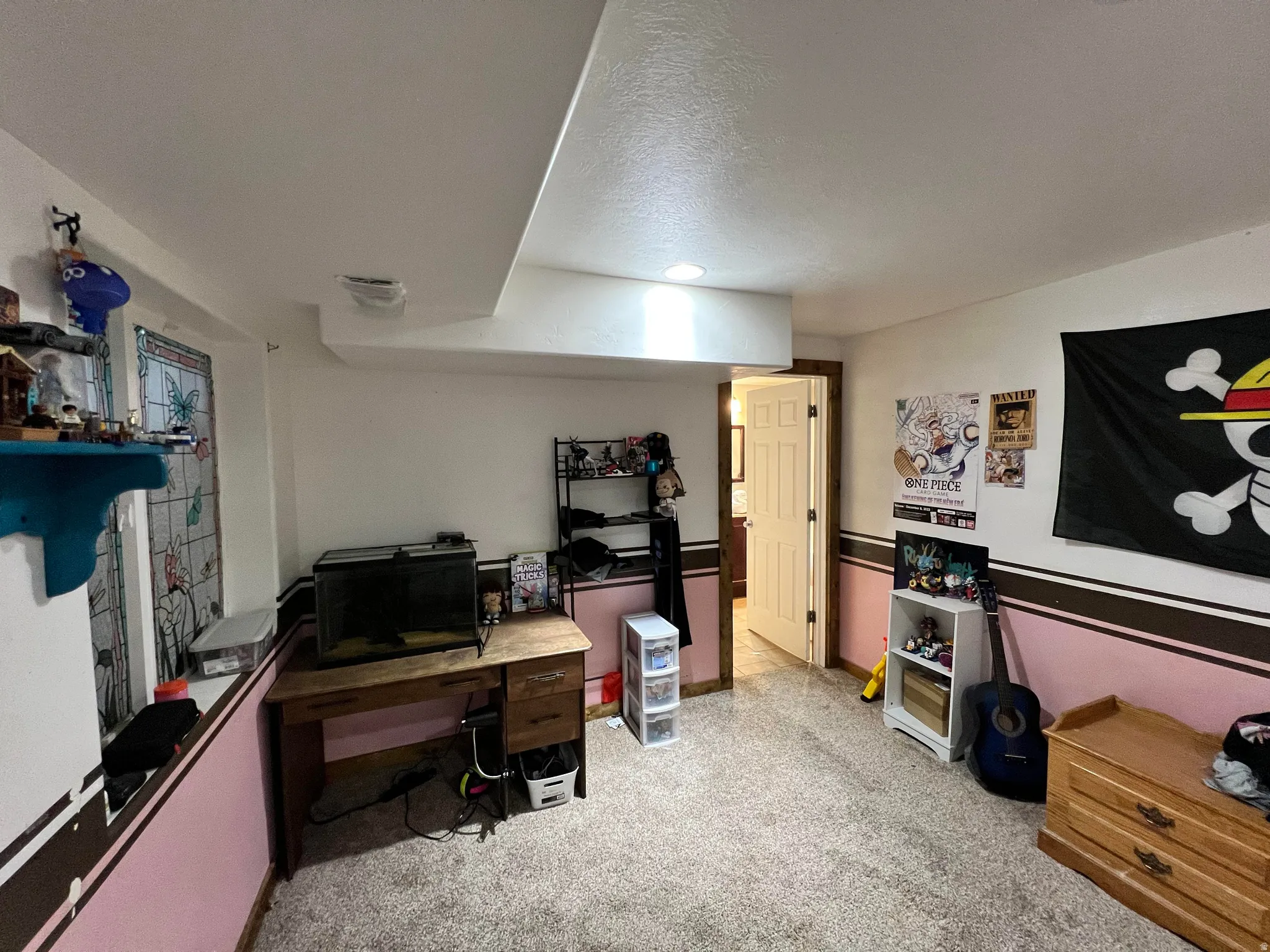 Home office with light colored carpet and a textured ceiling