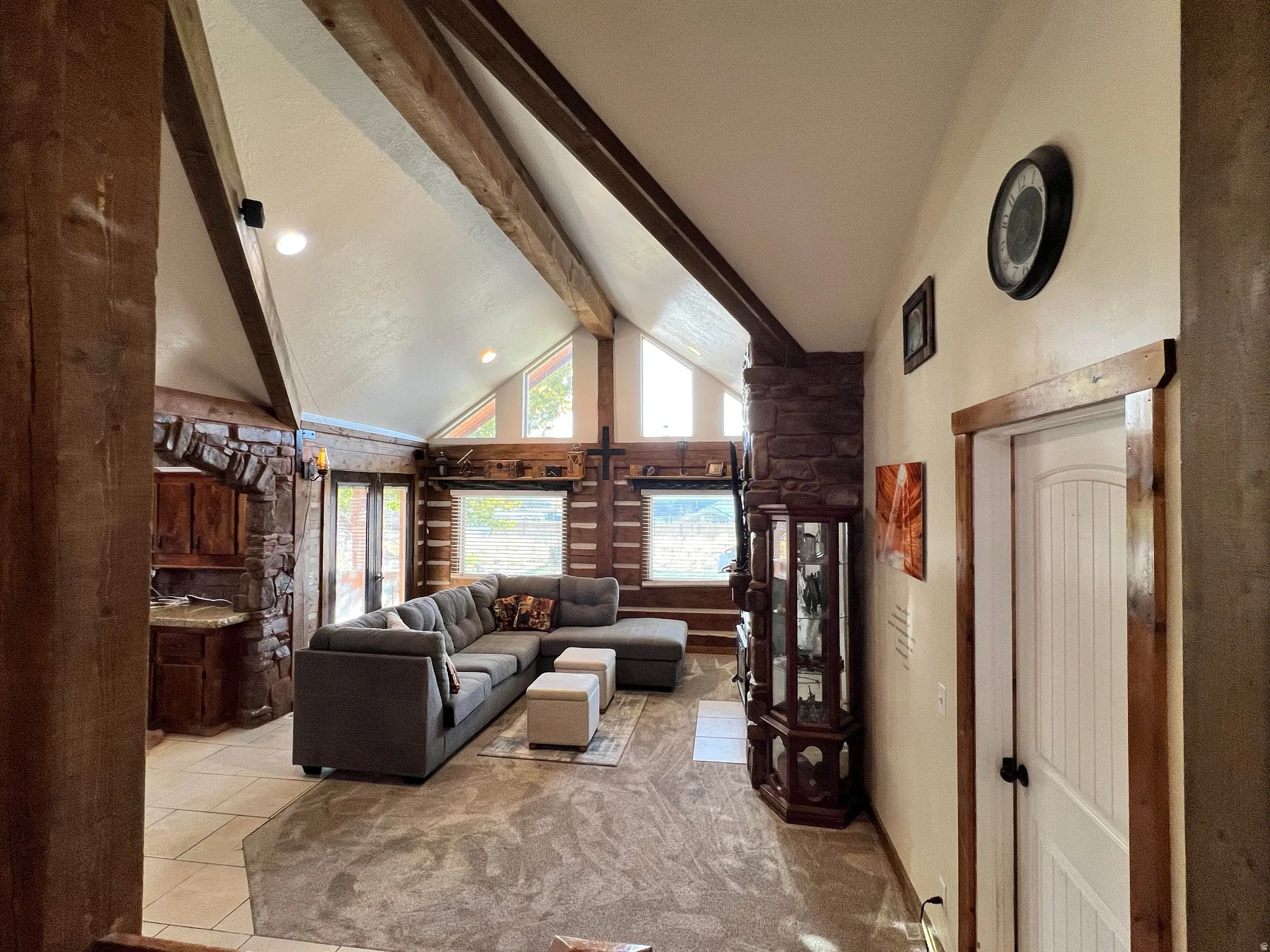 Living area with high vaulted ceiling, beam ceiling, light tile patterned floors, and recessed lighting