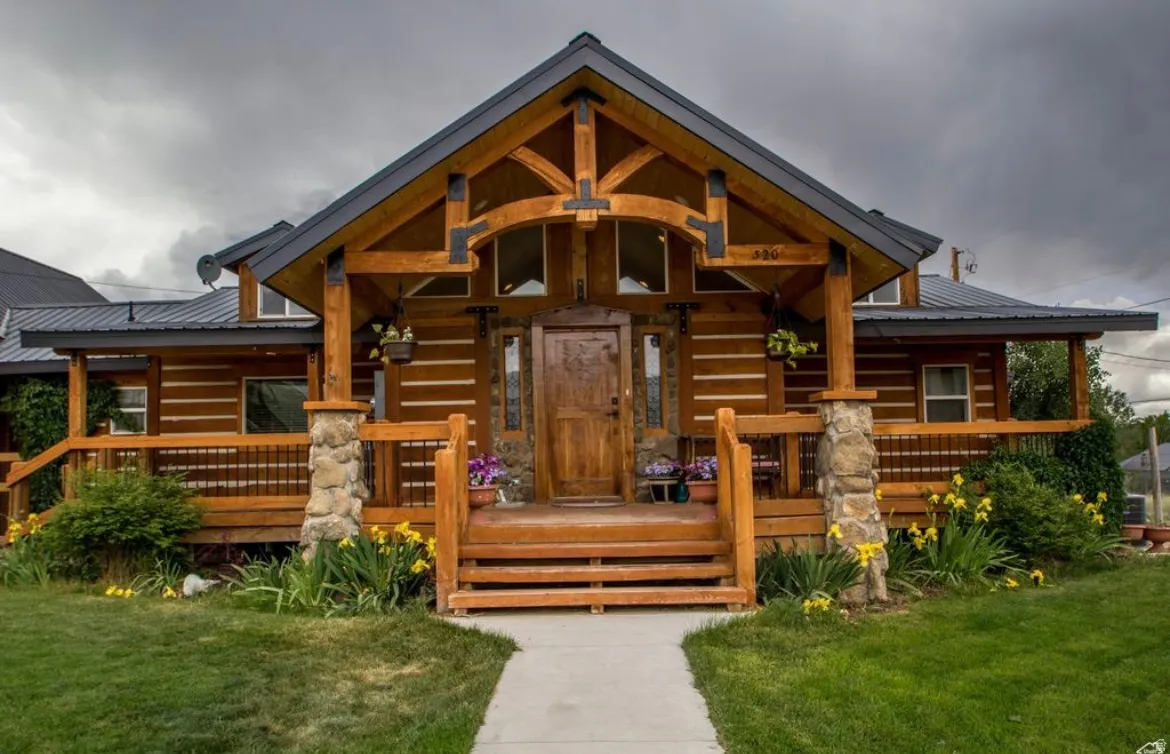 Cabin with covered porch, a metal roof, and a front yard